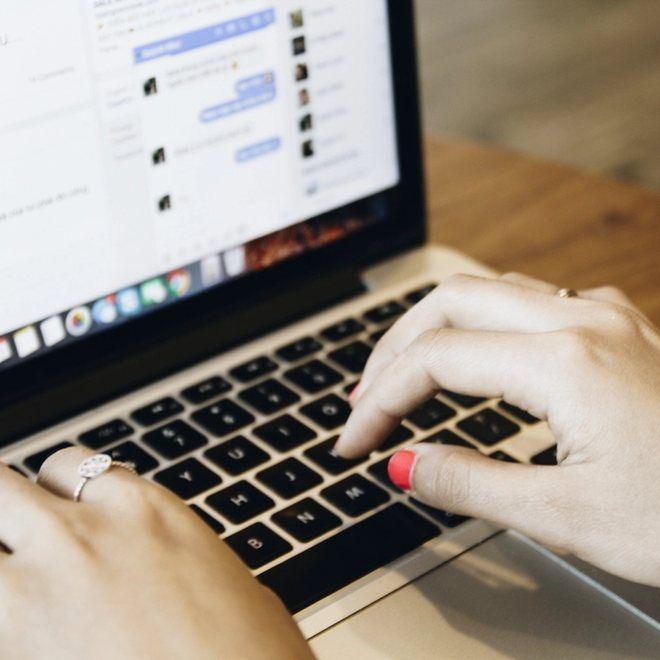 Hands typing code on a laptop at a desk